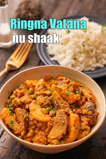 A bowl of Ringna Vatana nu Shaak (eggplant and green peas curry) garnished with coriander, served on a wooden table with a plate of rice in the background and Gujarati text on top.