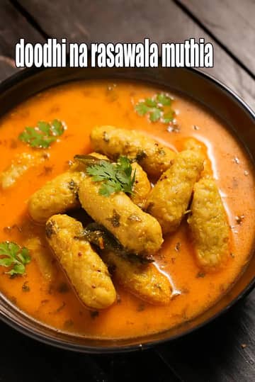 An image showing a black bowl filled with Doodhi na Rasawala Muthia, a traditional Gujarati dish. Several cylindrical, steamed bottle gourd dumplings (muthia) are submerged in a vibrant, thin orange-colored spiced gravy. The dish is garnished with fresh green coriander leaves and visible tempered spices like mustard seeds and curry leaves.