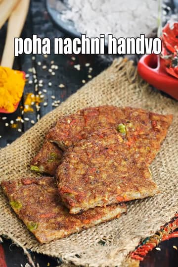 A top-down view of a golden-brown, crusty Poha Nachni Handvo garnished with sesame seeds and curry leaves, served with green chutney.
