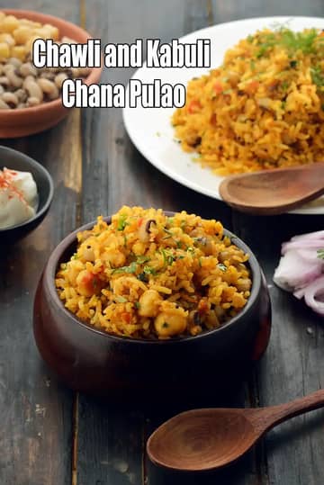 A bowl of Chawli and Kabuli Chana Pulao, made with spiced rice, black-eyed beans and chickpeas, garnished with fresh coriander, served on a rustic wooden table with onions and condiments on the side.