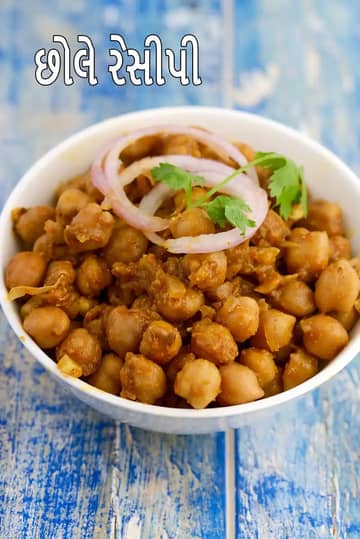 સફેદ વાટકામાં પીરસેલા સૂકા પ્રકારના પંજાબી છોલે, મસાલામાં રાંધેલા કાબૂલી ચણા, ઉપર ડુંગળીના વળયો અને તાજું લીલું ધાણું સજાવેલું, નીલા લાકડાના પૃષ્ઠભૂમિ પર રાખેલું.