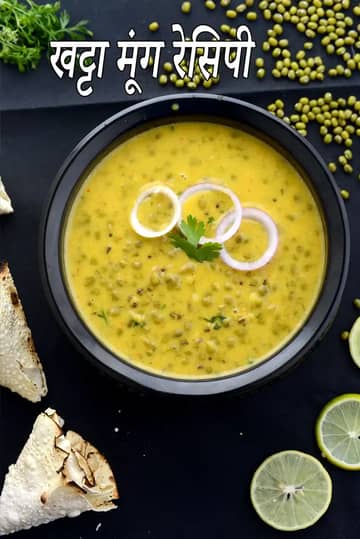 साबुत हरे मूंग से बनी खट्टा मूंग की सब्ज़ी, खट्टी पीली ग्रेवी में पकाई गई, ऊपर से प्याज के छल्ले और हरा धनिया डालकर काले बाउल में परोसी गई।