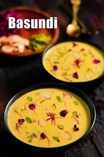 Gujarati basundi served in black bowls, a thick saffron-flavored milk dessert garnished with almonds, pistachios, rose petals, and saffron strands, placed on a dark rustic surface.