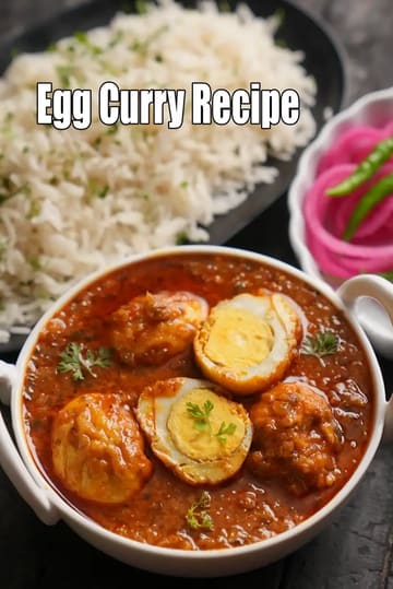 A white bowl filled with a rich, aromatic Egg Curry featuring halved boiled eggs in a thick tomato-based gravy, garnished with fresh coriander. It is served with a side of long-grain white rice and a small bowl of pickled pink onions and green chilies.