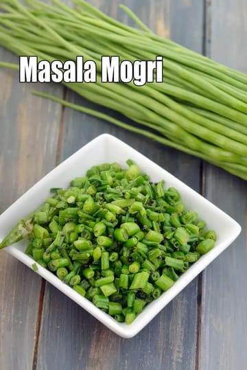 A close-up image of freshly chopped green mogri (radish pods) served in a white square bowl, placed on a rustic wooden surface, with whole green mogri pods kept in the background.