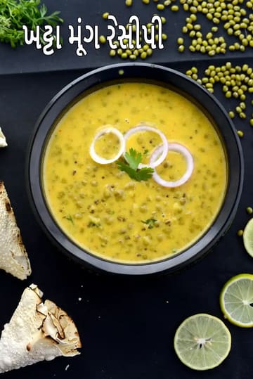 સાબૂત લીલા મૂંગથી બનેલી ખાટ્ટા મૂંગની શાક, ખાટી પીળી ગ્રેવીમાં તૈયાર કરેલી, ઉપરથી ડુંગળીના રિંગ્સ અને લીલું ધાણાં ઉમેરીને કાળા બાઉલમાં પીરસેલી।