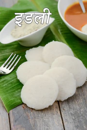 केले के पत्ते पर परोसी गई नरम और फूली हुई दक्षिण भारतीय इडली, साथ में नारियल की चटनी और सांभर