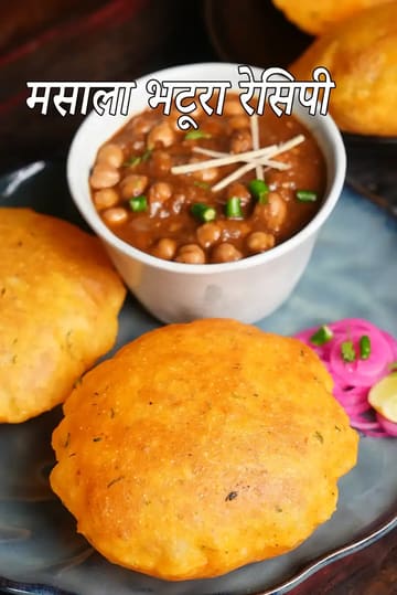 मसाला भटूरा एक प्लेट में परोसा गया है, साथ में मसालेदार छोले की कटोरी है जिस पर अदरक और हरी मिर्च से गार्निश किया गया है, साथ में हरी चटनी, प्याज़ का अचार और नींबू रखा है।