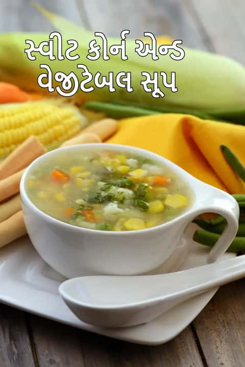 સફેદ રંગના એક મોટા બાઉલમાં ભરેલું સ્વીટ કોર્ન અને વેજીટેબલ સૂપ, જેમાં મકાઈના પીળા દાણા, સમારેલી ગાજર અને લીલી ડુંગળી વાળો સાફ અને પૌષ્ટિક વેજીટેબલ સૂપ છે.