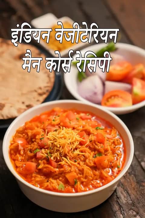 भारतीय मुख्य भोजन की शाकाहारी थाली जिसमें मसालेदार सब्ज़ी, रोटी, कटे हुए प्याज़ और टमाटर परोसे गए हैं