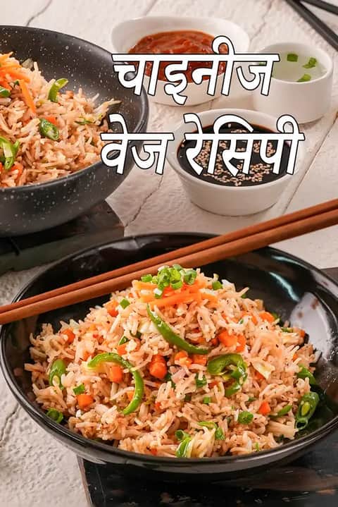 काले बाउल में परोसा गया वेजिटेरियन चाइनीज़ फ्राइड राइस, जिसमें गाजर, शिमला मिर्च और हरे प्याज़ जैसी रंग-बिरंगी सब्ज़ियाँ मिली हुई हैं, ऊपर चॉपस्टिक्स रखी हैं और साथ में सोया सॉस व चिली सॉस के बाउल हैं