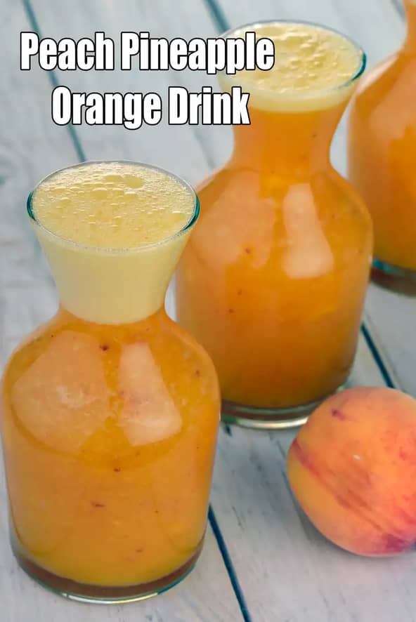 Three small glass bottles filled with a frothy peach, pineapple, and orange drink are placed on a wooden surface. The drink has a smooth, pulpy texture with light foam on top, and a fresh whole peach is kept beside the bottles, highlighting the fruity ingredients.