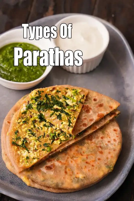 Parathas served on a plate with green chutney and curd