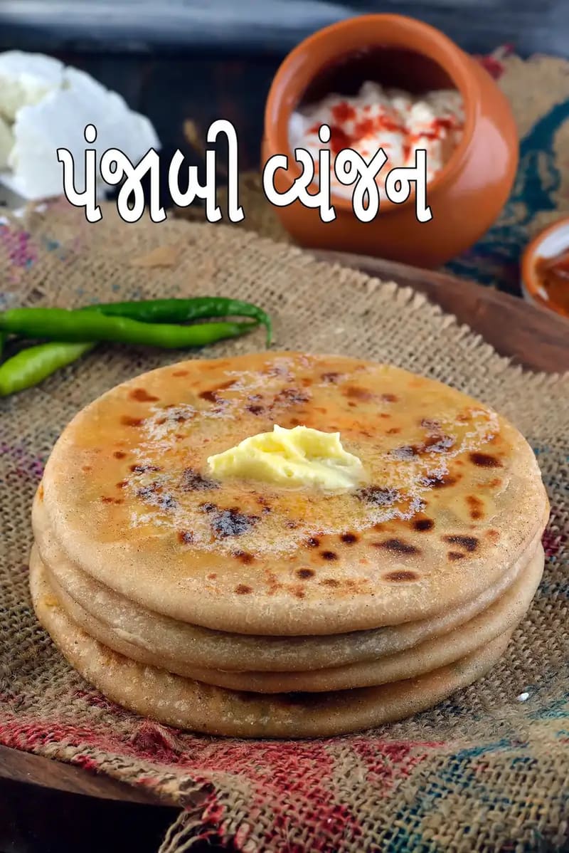 માખણ મૂકેલા તાજા બનાવેલા ભારતીય સ્ટફ્ડ પરાઠાની ગોઠવણ, જેને ગામઠી કાપડ પર પીરસવામાં આવી છે, સાથે લીલા મરચાં, દહીં અને અથાણું રાખેલું છે।