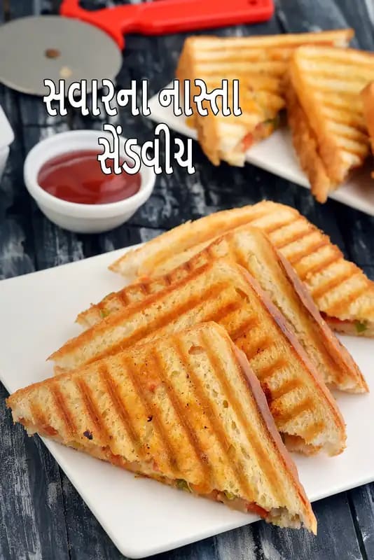 ત્રિકોણ બ્રેડ સ્લાઇસથી બનેલા વેજિટેરિયન બ્રેકફાસ્ટ સેન્ડવિચ, શાકભાજી ફિલિંગ અને લેટ્યુસ ગાર્નિશ સાથે, કેચપ અને મેયો ડિપ્સ સાથે સર્વ કરેલા।