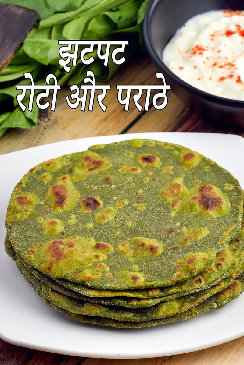 सफेद प्लेट में परोसी गई झटपट हरी रोटियाँ या पराठे, पत्तेदार सब्ज़ियों से बने हुए, हल्के से सेंके गए, पीछे दही और ताज़ी हरी सब्ज़ियाँ दिखाई दे रही हैं।