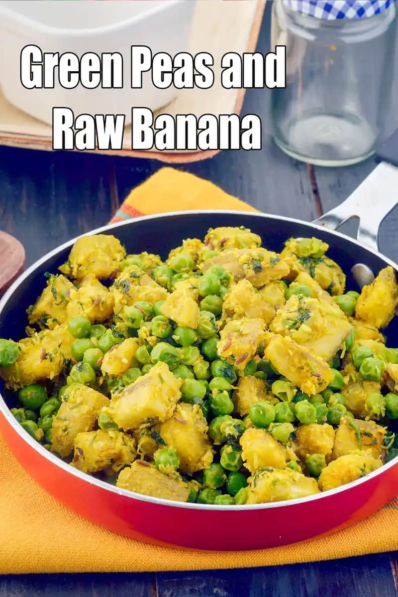 A close-up view of a pan filled with green peas and raw banana sabzi, showing tender chunks of raw banana mixed with fresh green peas, lightly spiced and cooked, placed on a yellow cloth with kitchen items in the background.